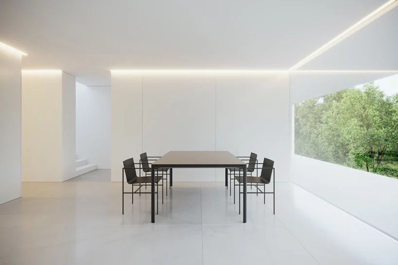 Dining room with stark white walls and black furniture. 
