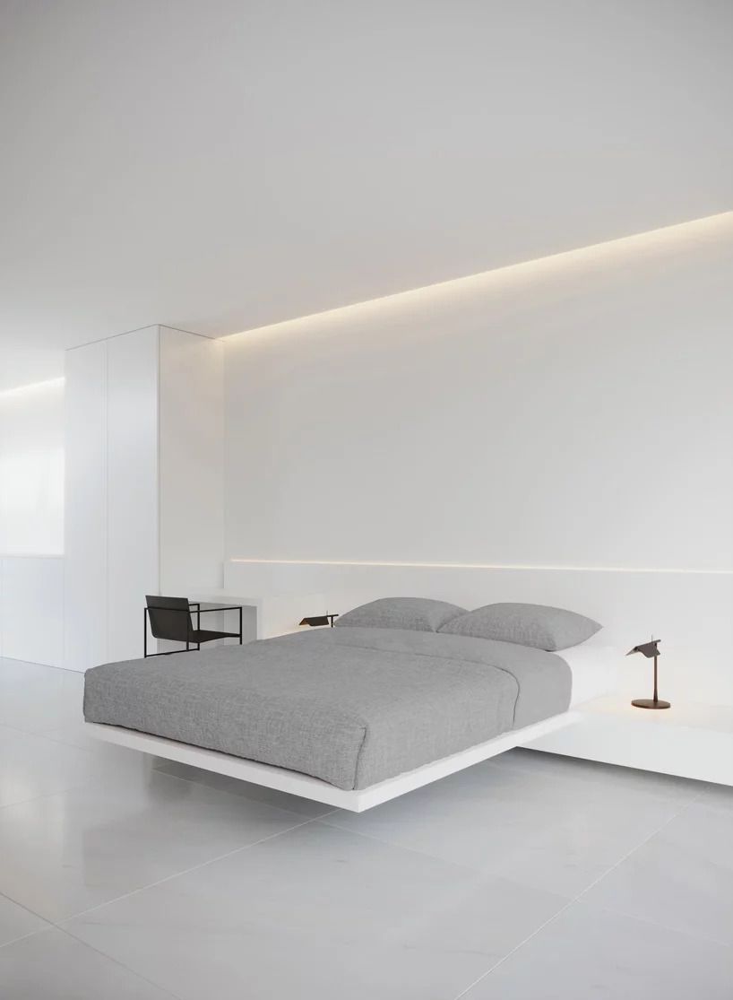 Floating bed with gray bedding attached to wall in bedroom.