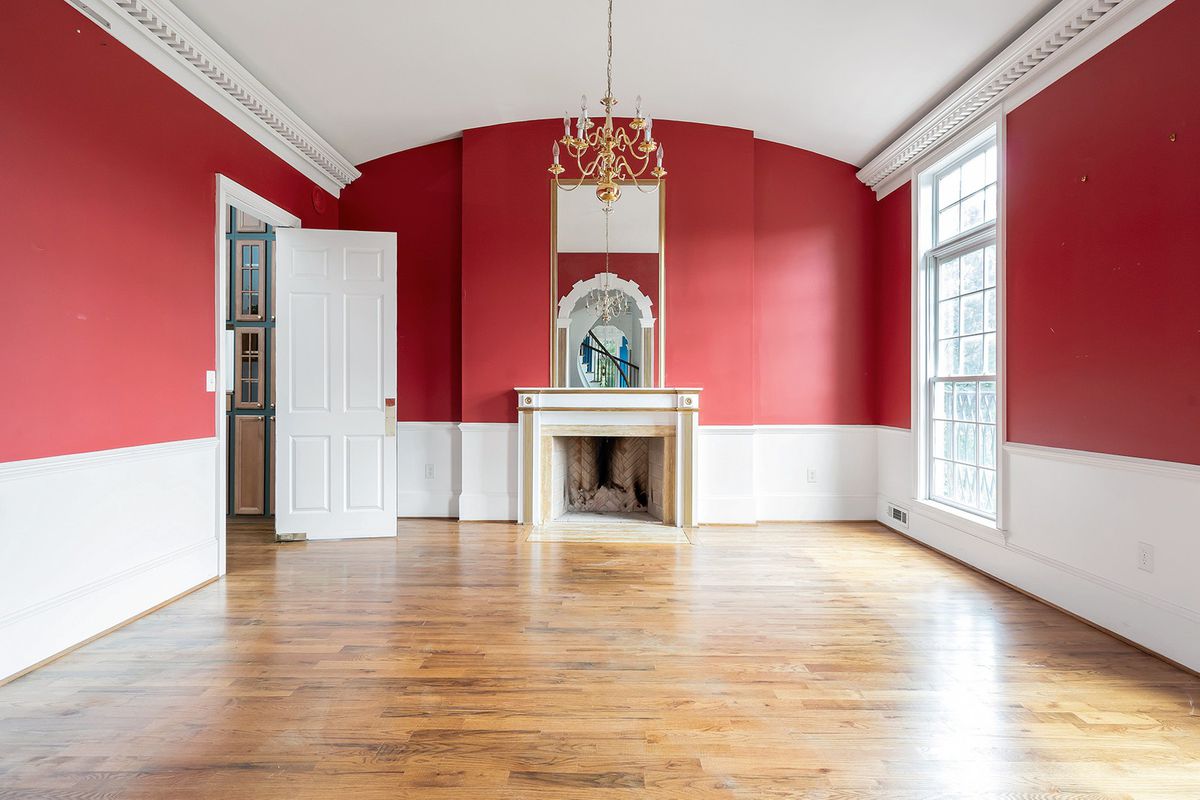 A huge red dining room with a big fireplace. 