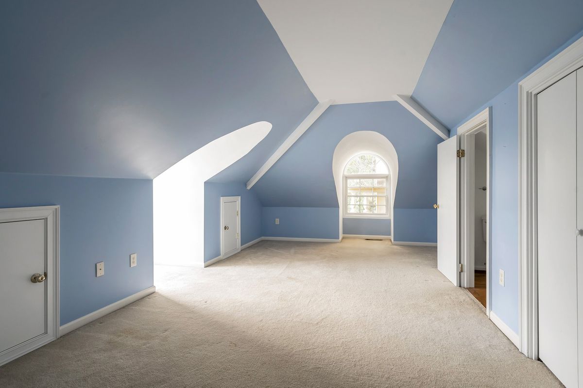 A long blue room in the attic of a classical house. 