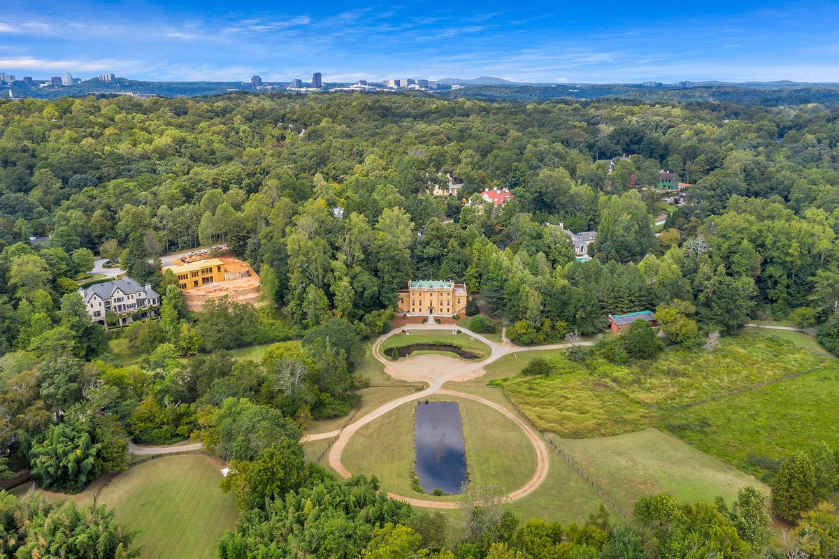 A huge green property with trees for miles.