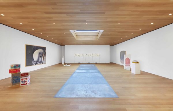 a large room with wood paneling and white walls and art 