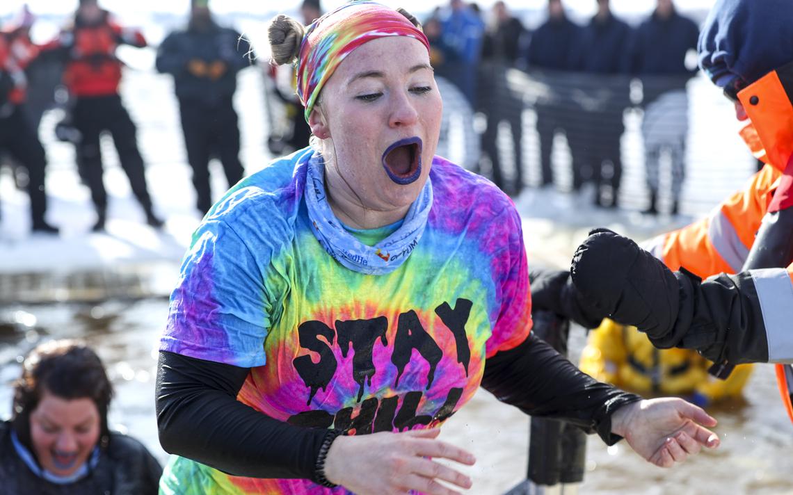 A woman with a shirt that reads "Stay chill" hurries out of the freezing water after taking the Duluth Plunge Saturday, Feb. 15, 2020, on Park Point. People from UnitedHealth Group dressed in tie-dye to support the cause. (Tyler Schank / tschank@duluthnews.com)
