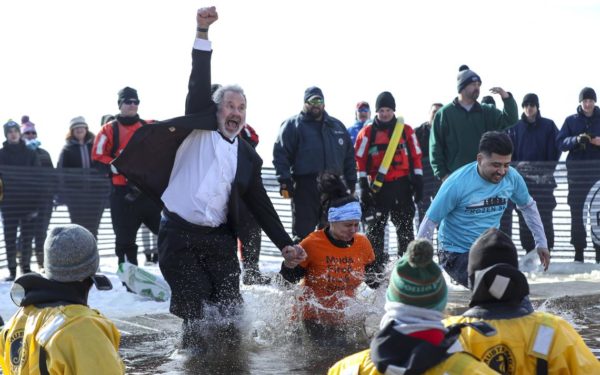 A man wearing a tuxedo raises his fist in the air as he takes the Duluth Plunge Saturday, Feb. 15, 2020, on Park Point. (Tyler Schank / tschank@duluthnews.com)