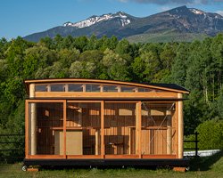 tono mirai's 'red container' in japan is a micro dwelling made almost entirely from larch wood