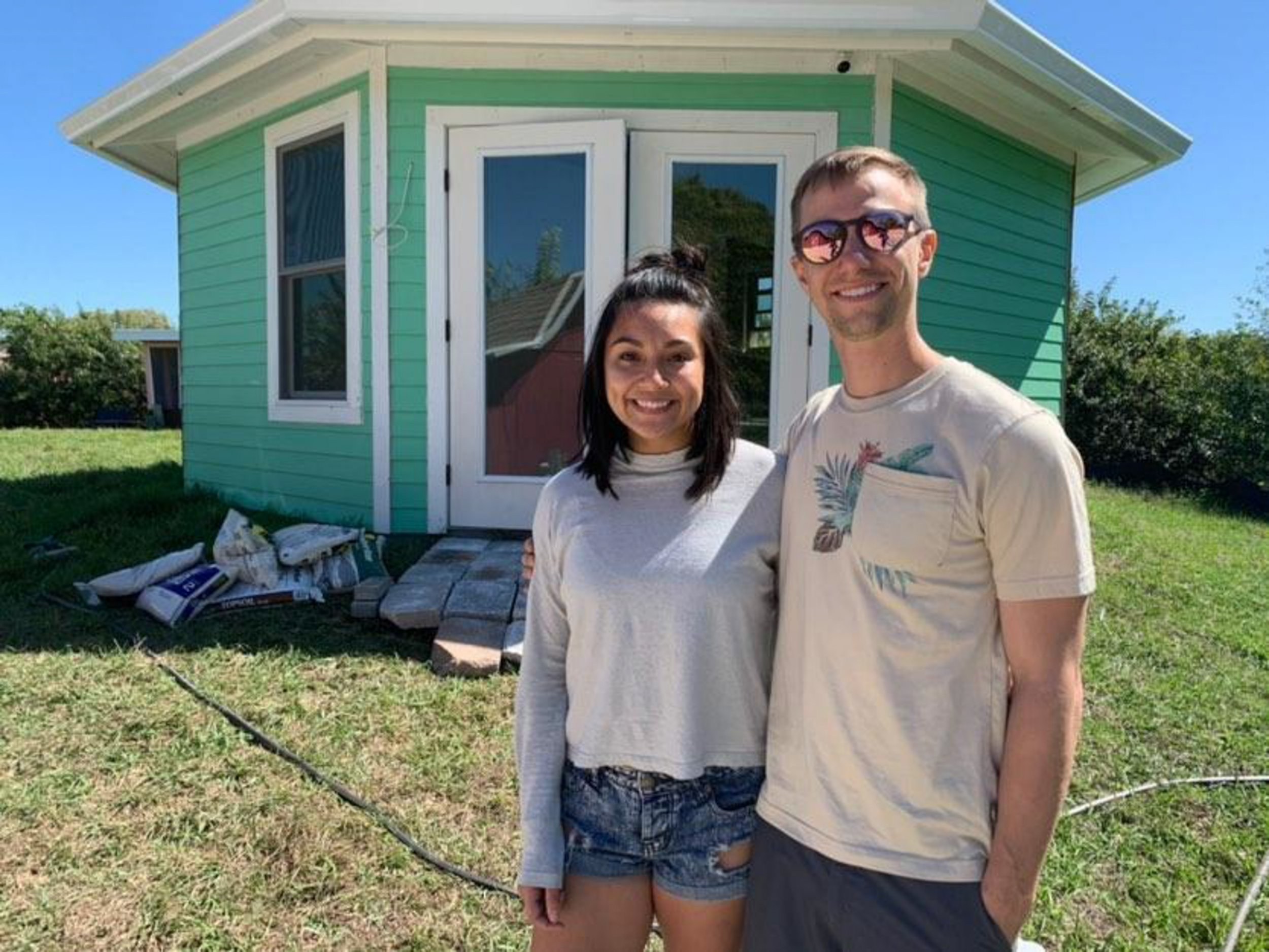 Sam and Tim outside Octagon house, the tiny house they had built on their own peninsula