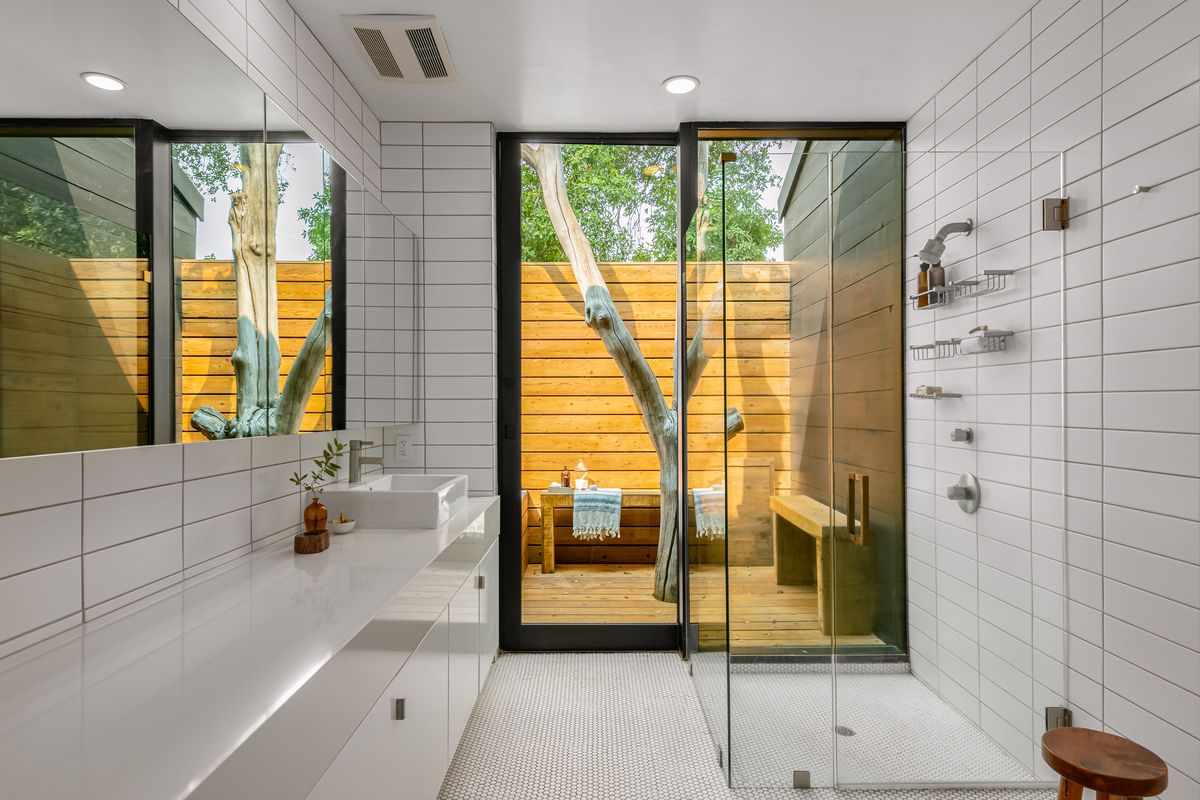 Bathroom with white tile and glass shower.