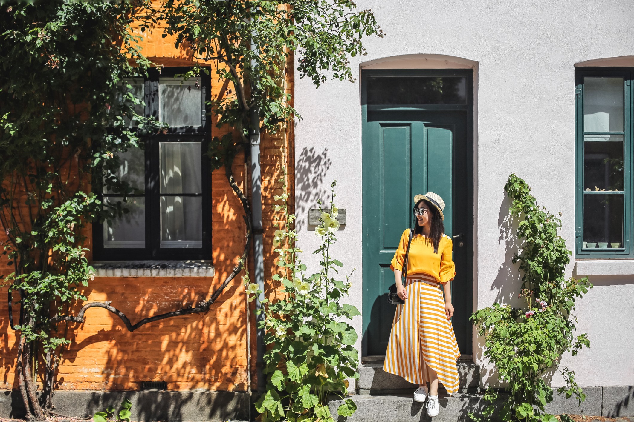 Young woman standing in front of colorful buildings in Copenhagen, Denmark