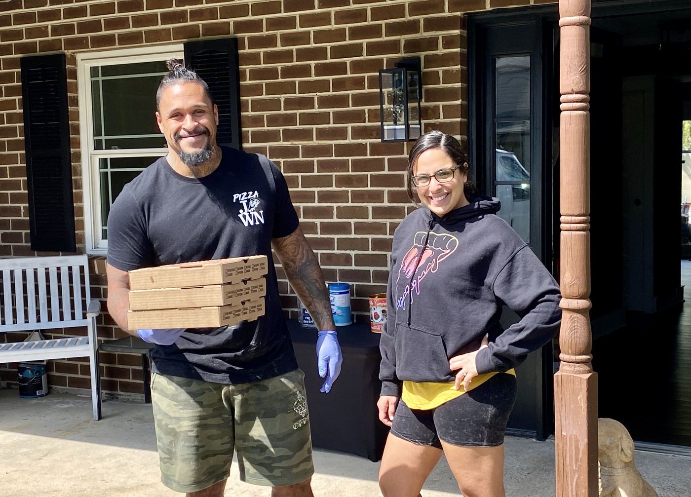 David and Ana Lee of Pizza Jawn outside of their house with pizzas for pickup.