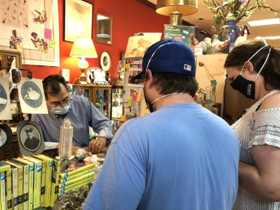 Photo - Art Aguirre, owner of Magnolia Antique Mall in Guthrie, helps customers in his store. [PAM OLSON FOR THE OKLAHOMAN] 