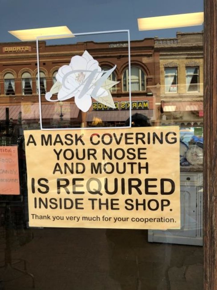 Photo - A sign is posted on the door at Magnolia Antique Mall in Guthrie, indicating the need for a mask. [PAM OLSON FOR THE OKLAHOMAN] 