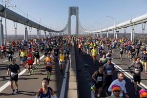 Sam Concepcion et al. standing in a parking lot: Runners compete in the 2019 New York City Marathon, November 11, 2019. Associated Press