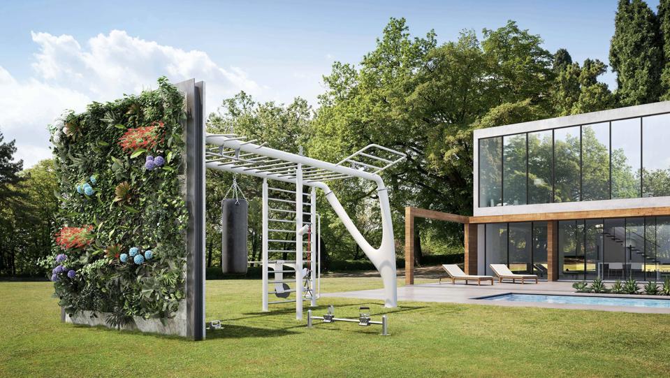 An outdoor home gym on a manicured lawn with a living wall.