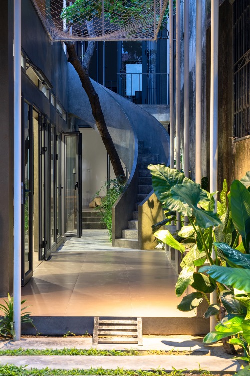 The staircase becomes a highlight of the middle garden, connecting the space downstairs with the greenery on the second floor.