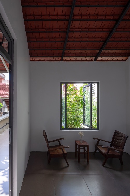 A window on the second floor has a garden view. The house uses traditional descending red brick roofs, connecting blocks with the gardens and make the whole construction more sustainable under the scorching sun of central Vietnam.The construction costed VND750,000 ($32,359).