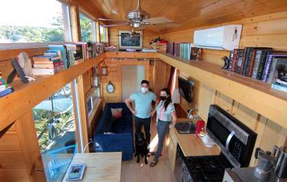 John McCarthy, his wife, Amy Garber, and their dog Winston, pose inside their tiny home along the waterfront in New Haven, Conn., on Thursday Oct. 8, 2020.