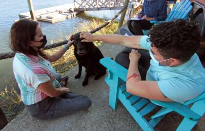 John McCarthy and his wife, Amy Garber, hang out with their dog Winston outside of their tiny home along the waterfront in New Haven, Conn., on Thursday Oct. 8, 2020.