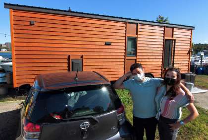 John McCarthy and his wife, Amy Garber, pose in front of their tiny home along the waterfront in New Haven, Conn., on Thursday Oct. 8, 2020.