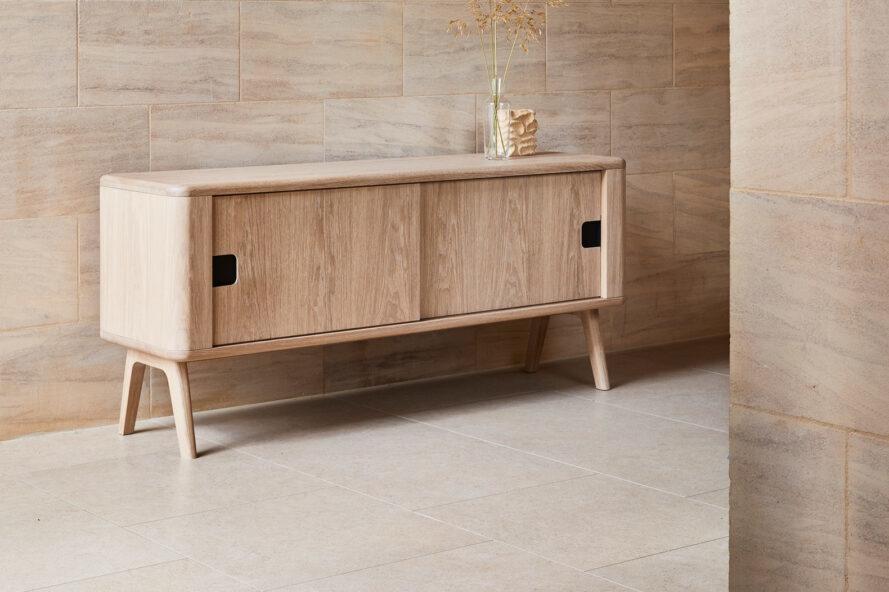 light wood credenza against tan wall